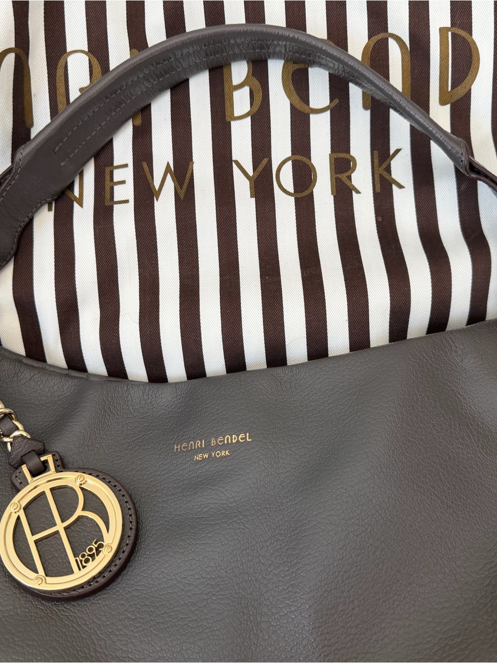 henri bendel brown leather hobo with gold logo charm